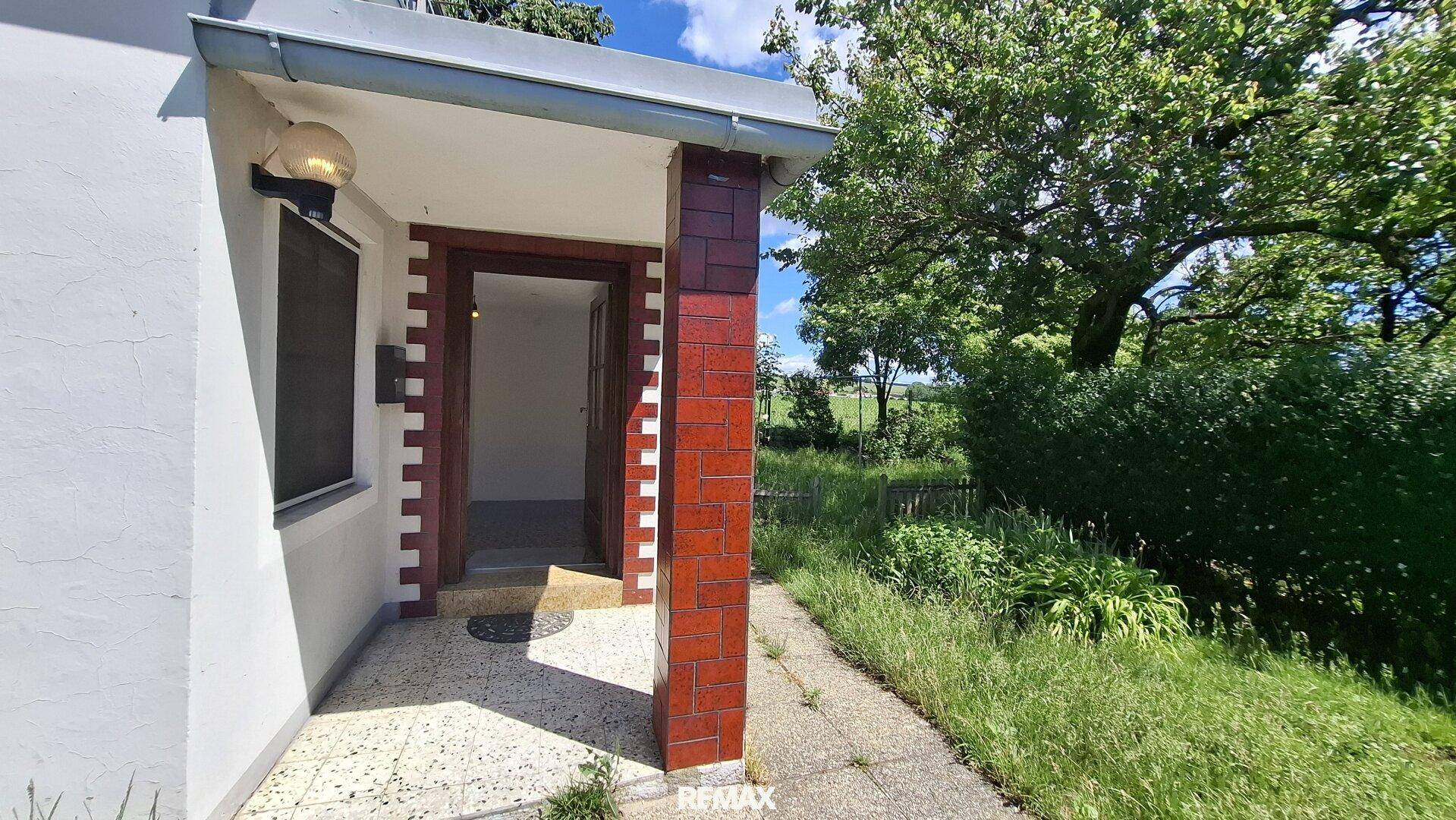 Eingangsbereich des Hauses mit überdachtem Vorbau und Zugang zum Inneren.