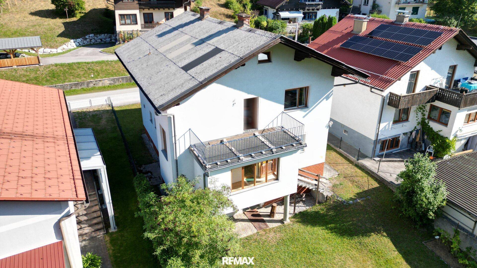 Luftaufnahme der Rückseite des Hauses mit Balkon, Garten und Blick auf die Umgebung.