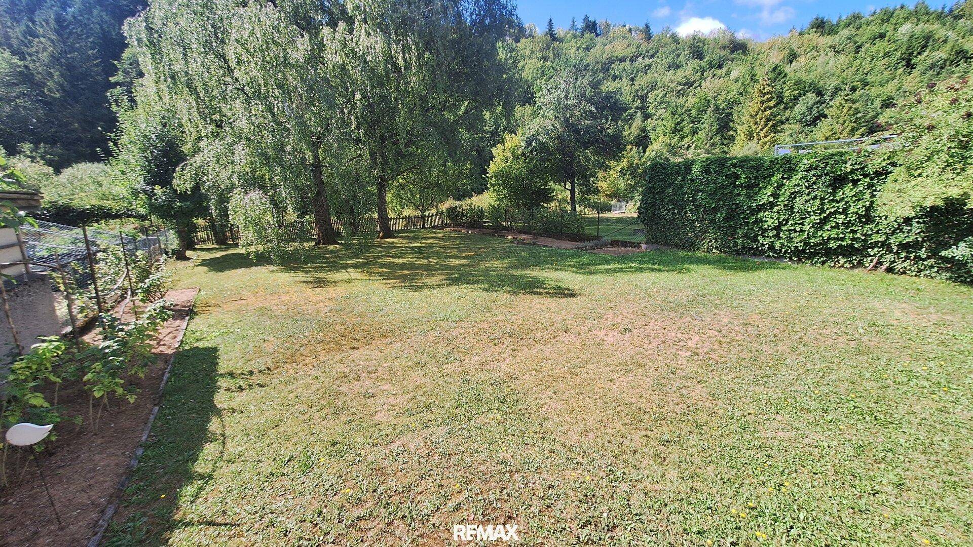 Großer, gepflegter Garten mit Rasenfläche, Bäumen und Hecken in ländlicher Umgebung.