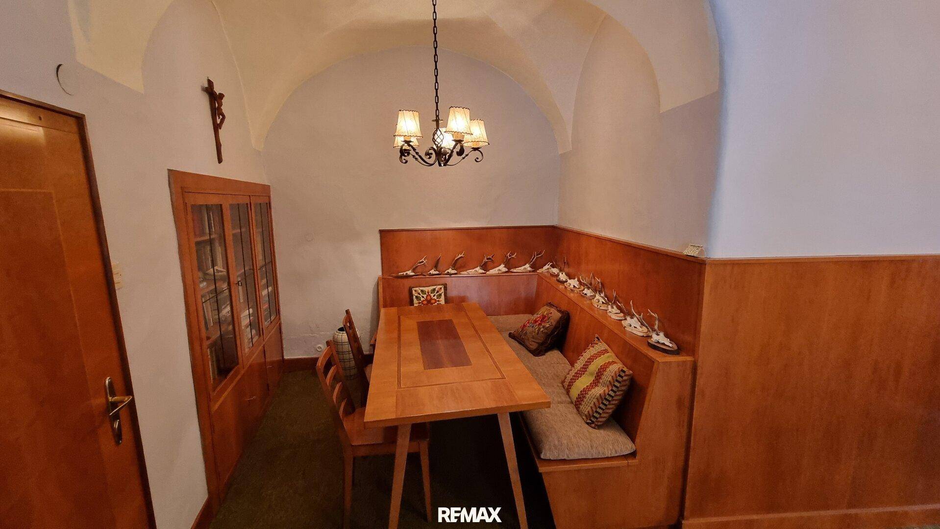 Traditioneller Essbereich mit Holzbänken, Esstisch und Gewölbedecke, gemütlich eingerichtet.