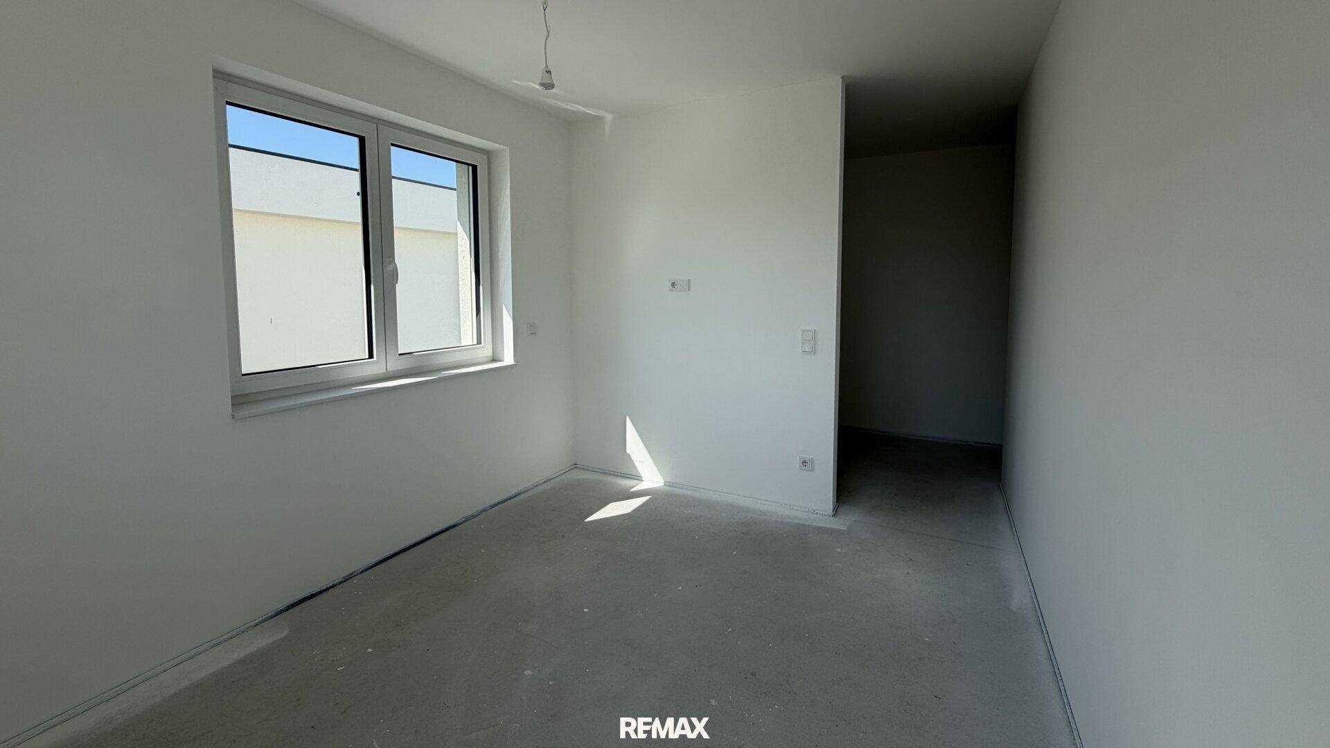 Unfertiges Zimmer mit einem Fenster, das viel Tageslicht hereinlässt.