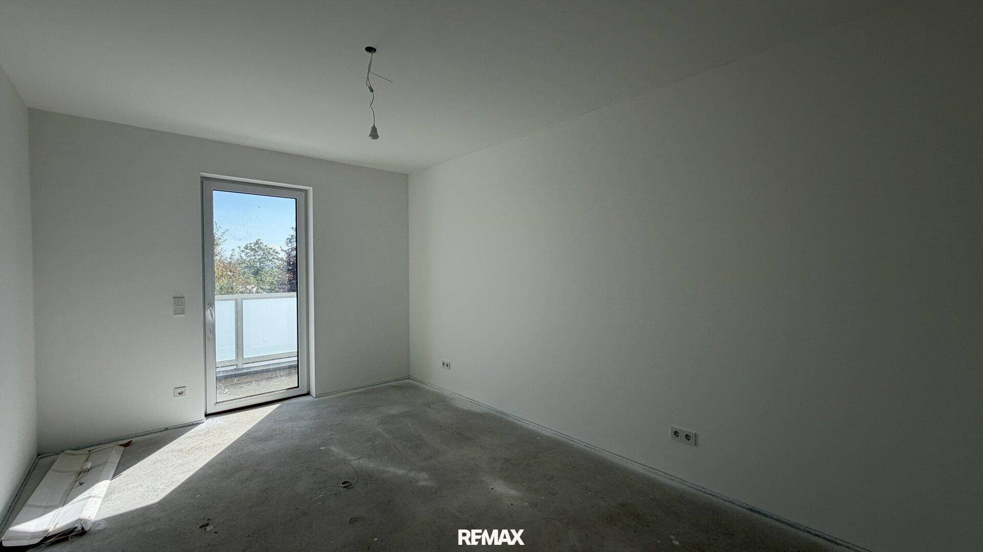 Helles Zimmer mit Zugang zu einem Balkon, ideal als Schlafzimmer nutzbar.