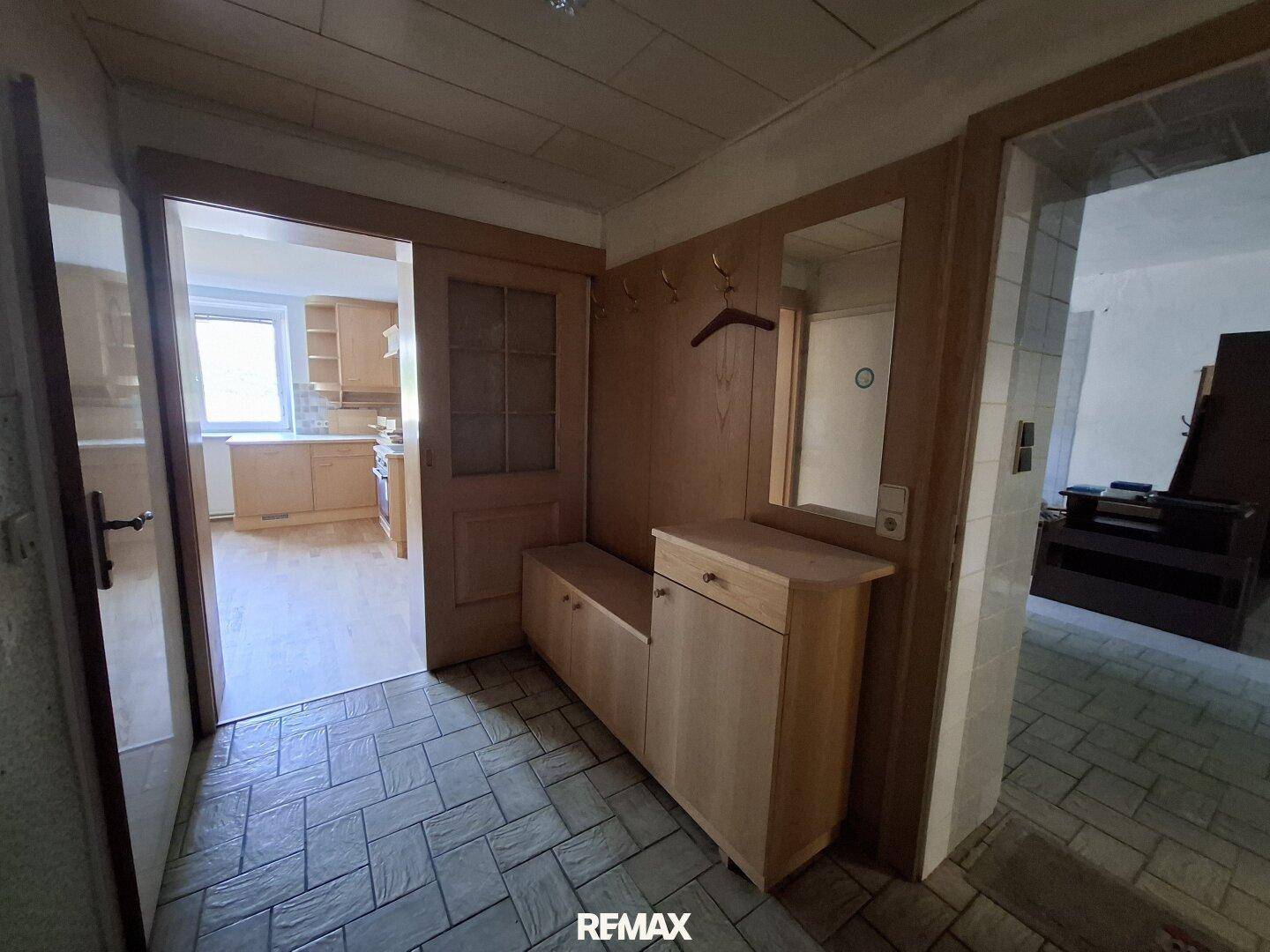 Eingangsbereich mit Fliesenboden, Garderobe und Zugang zu weiteren Räumen.