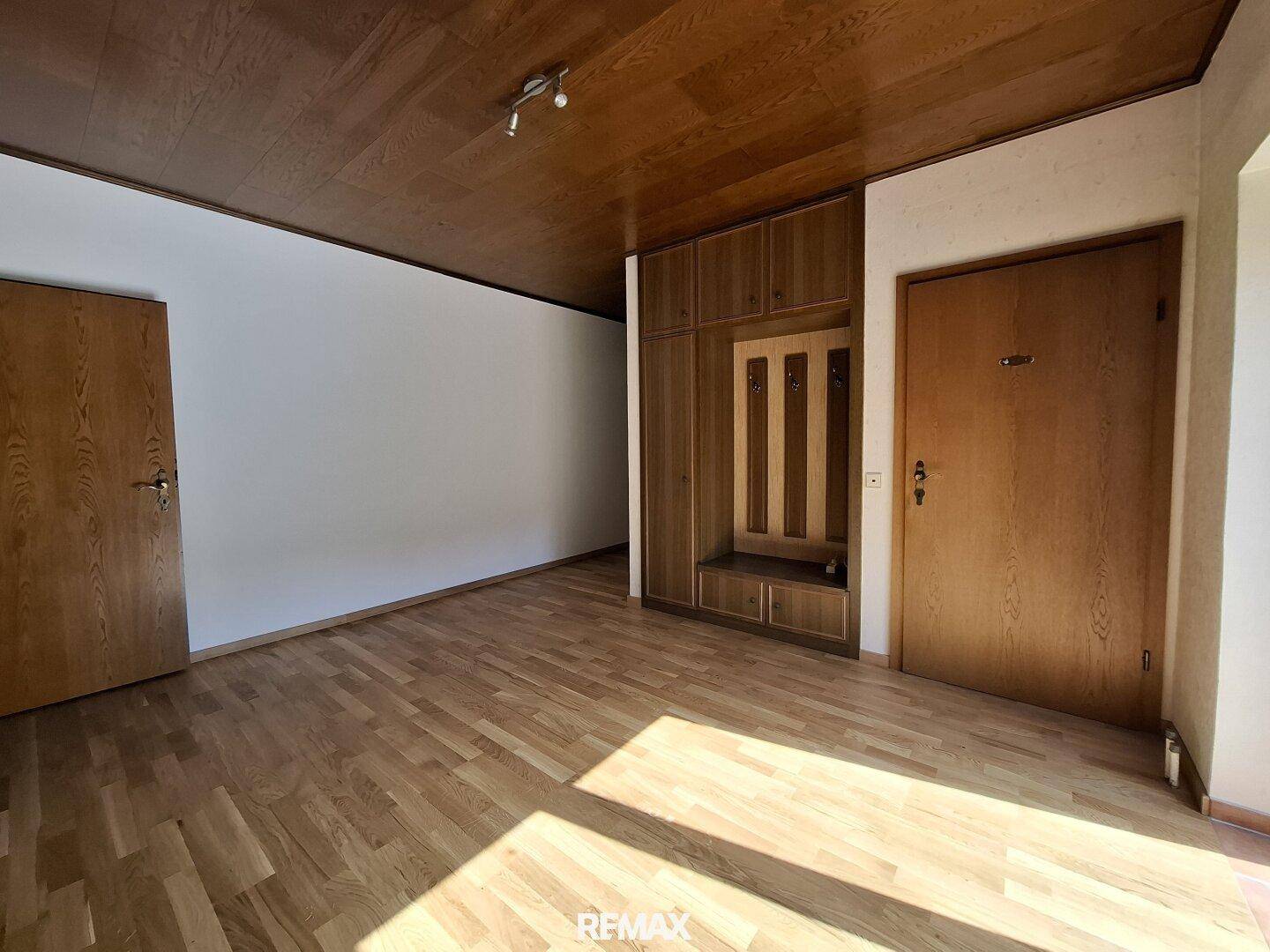 Geräumiges Schlafzimmer mit Holzdecke, Parkettboden und Einbauschrank.