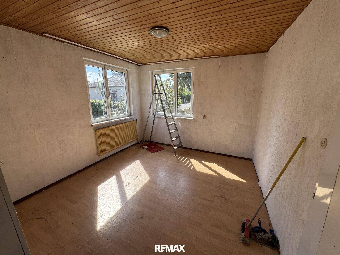 Helles Zimmer mit Holzdecke und Laminatboden, ideal für ein Wohn- oder Schlafzimmer.