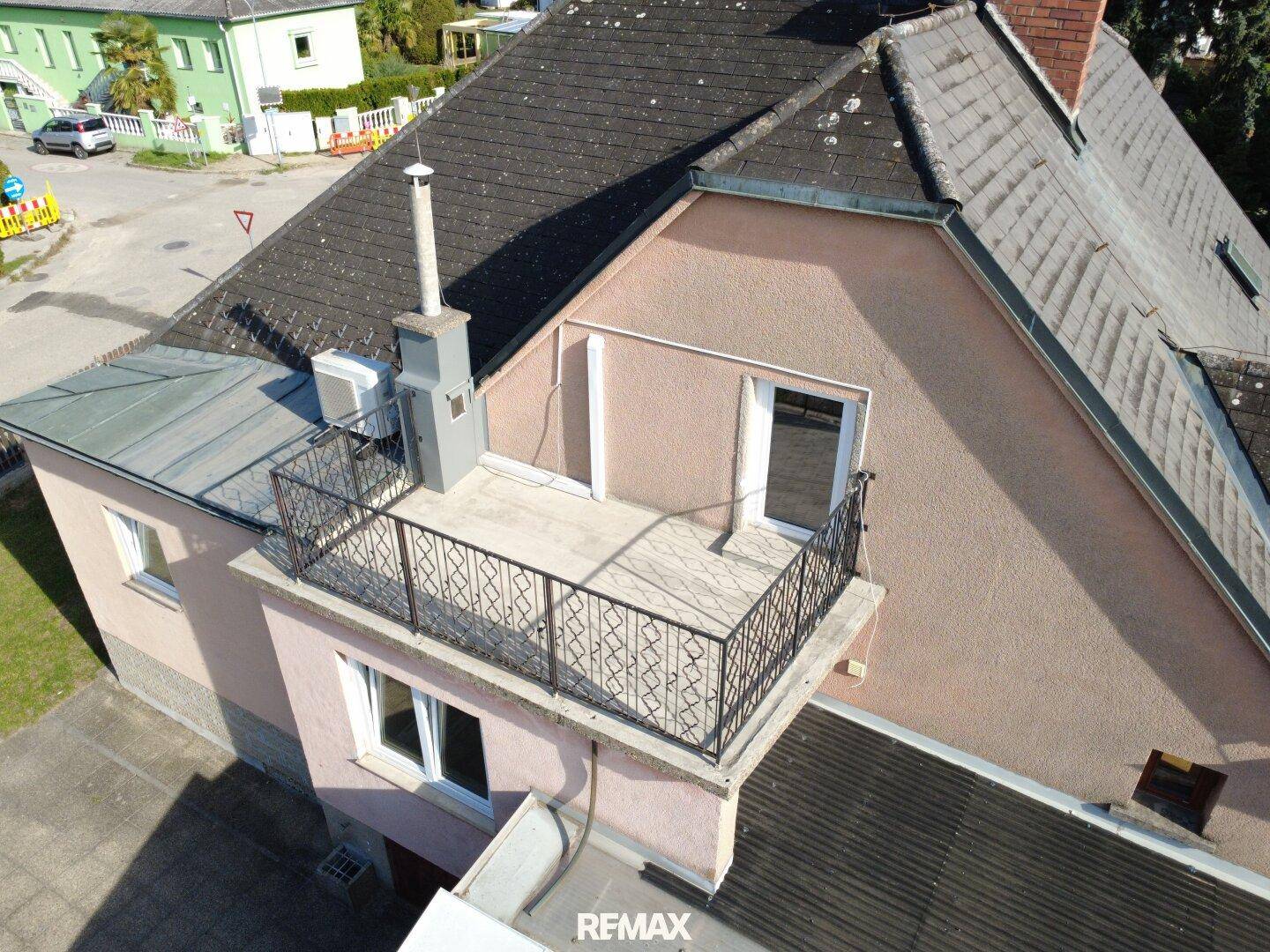 Kleiner Balkon mit schmiedeeisernem Geländer an der Hausfassade, bietet Außenbereich.