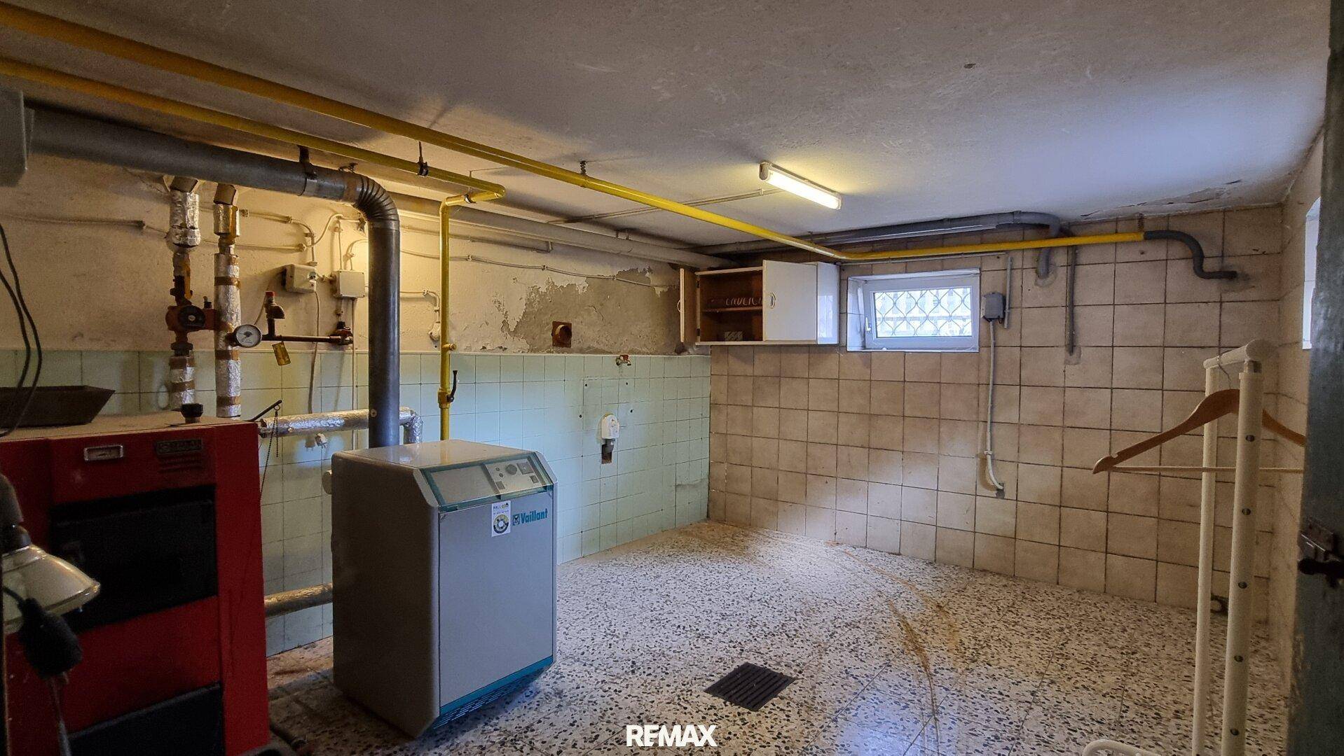 Heizungsraum im Keller mit Fliesenboden und sichtbaren Rohren, beherbergt die Heizungsanlage.