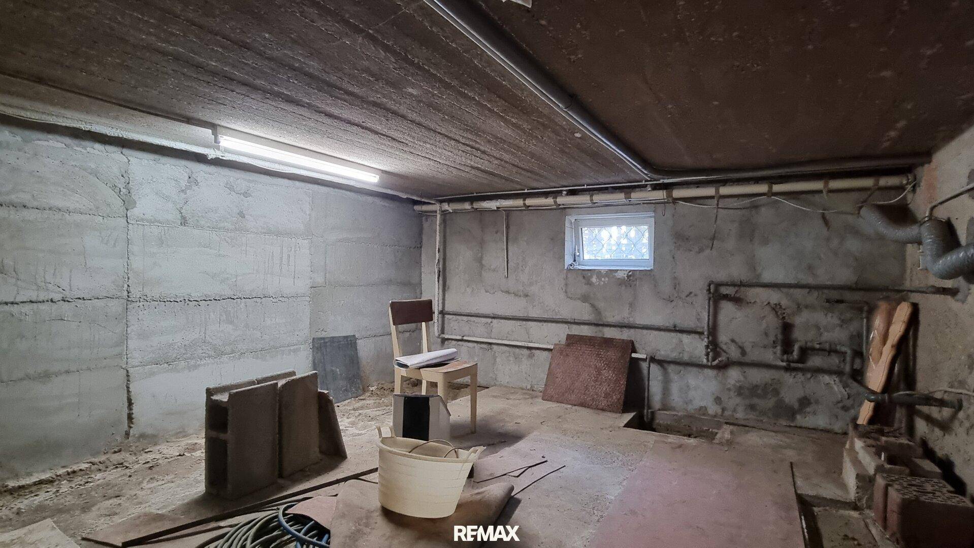 Unausgebauter Kellerraum mit Betonwänden und einem kleinen Fenster, bietet Stauraum.