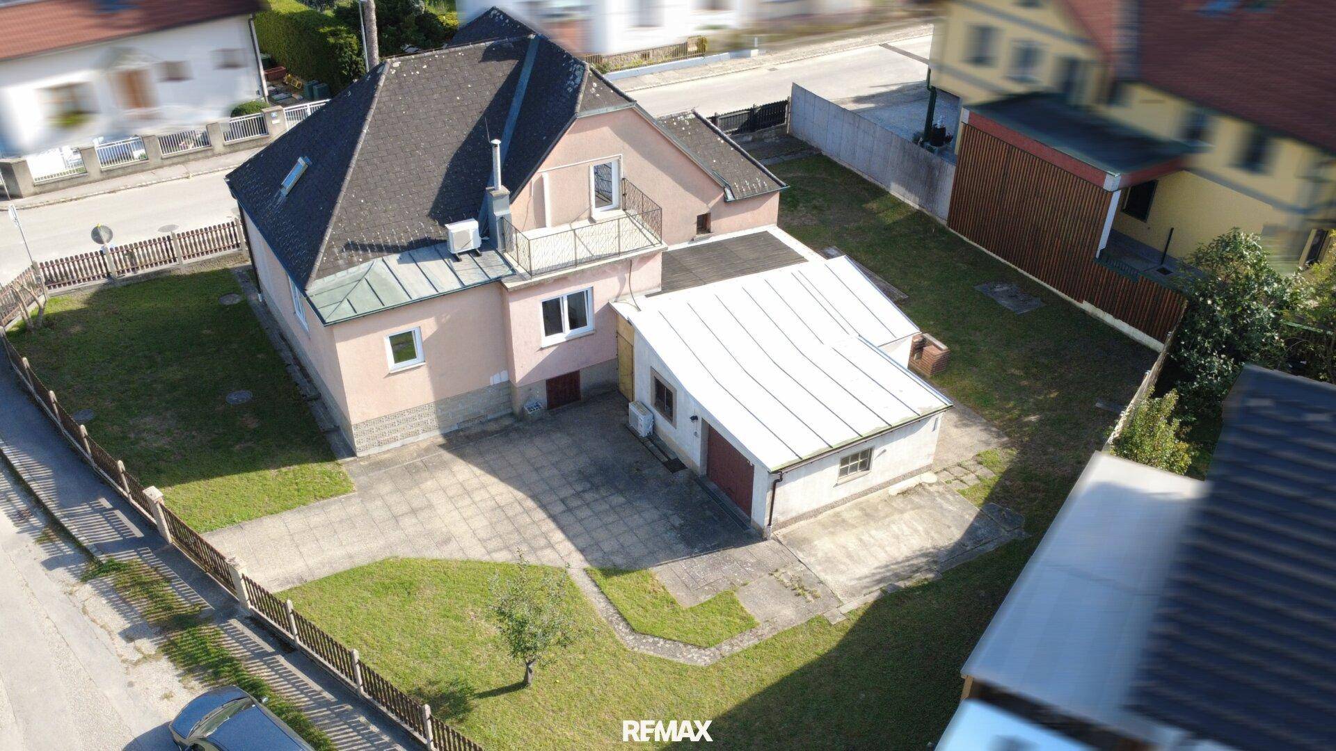 Luftaufnahme des Hauses mit separater Garage und großem Gartenbereich.