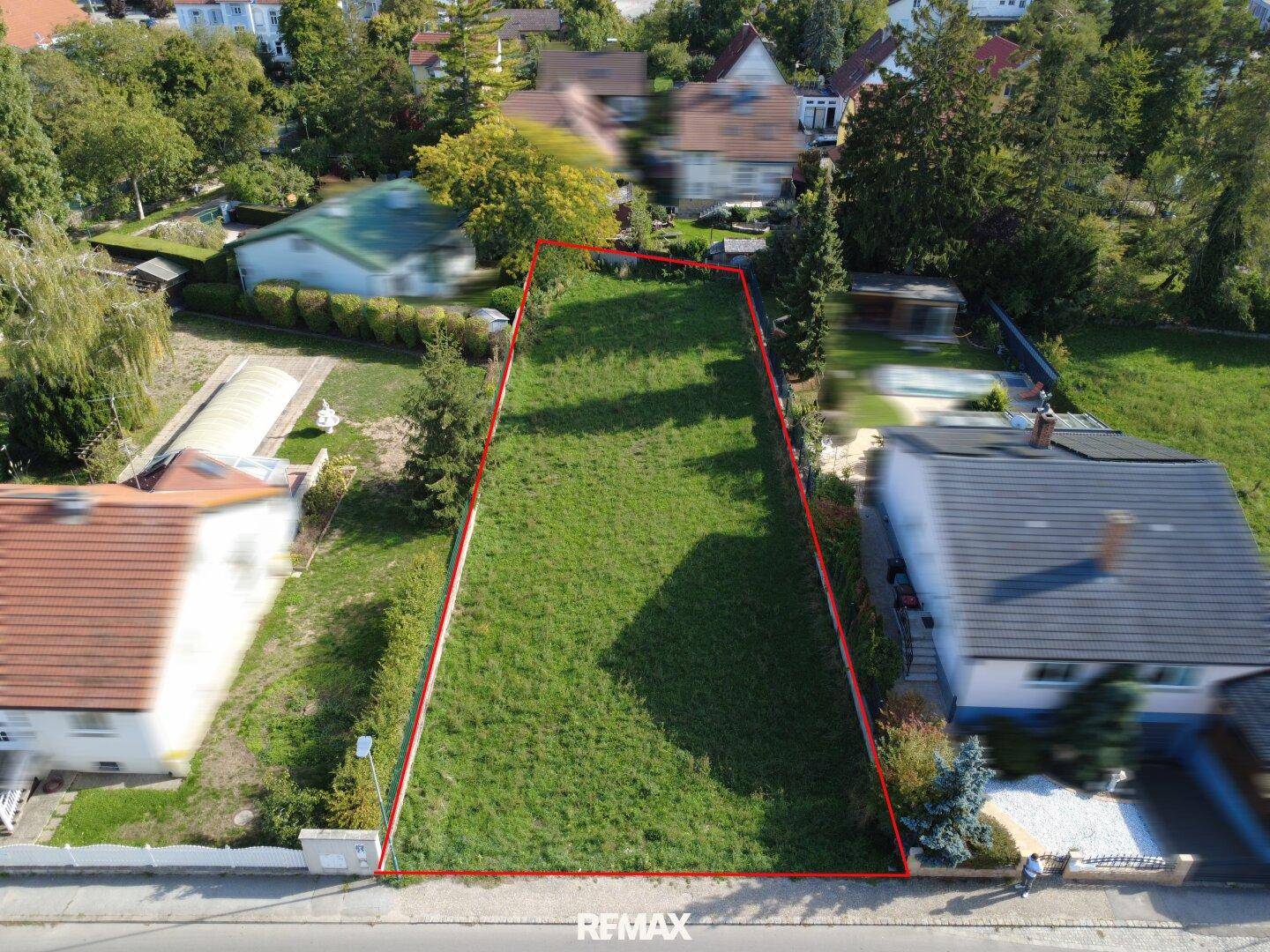 Übersichtsaufnahme des Baugrundstücks mit klarer Abgrenzung und angrenzender Straße.