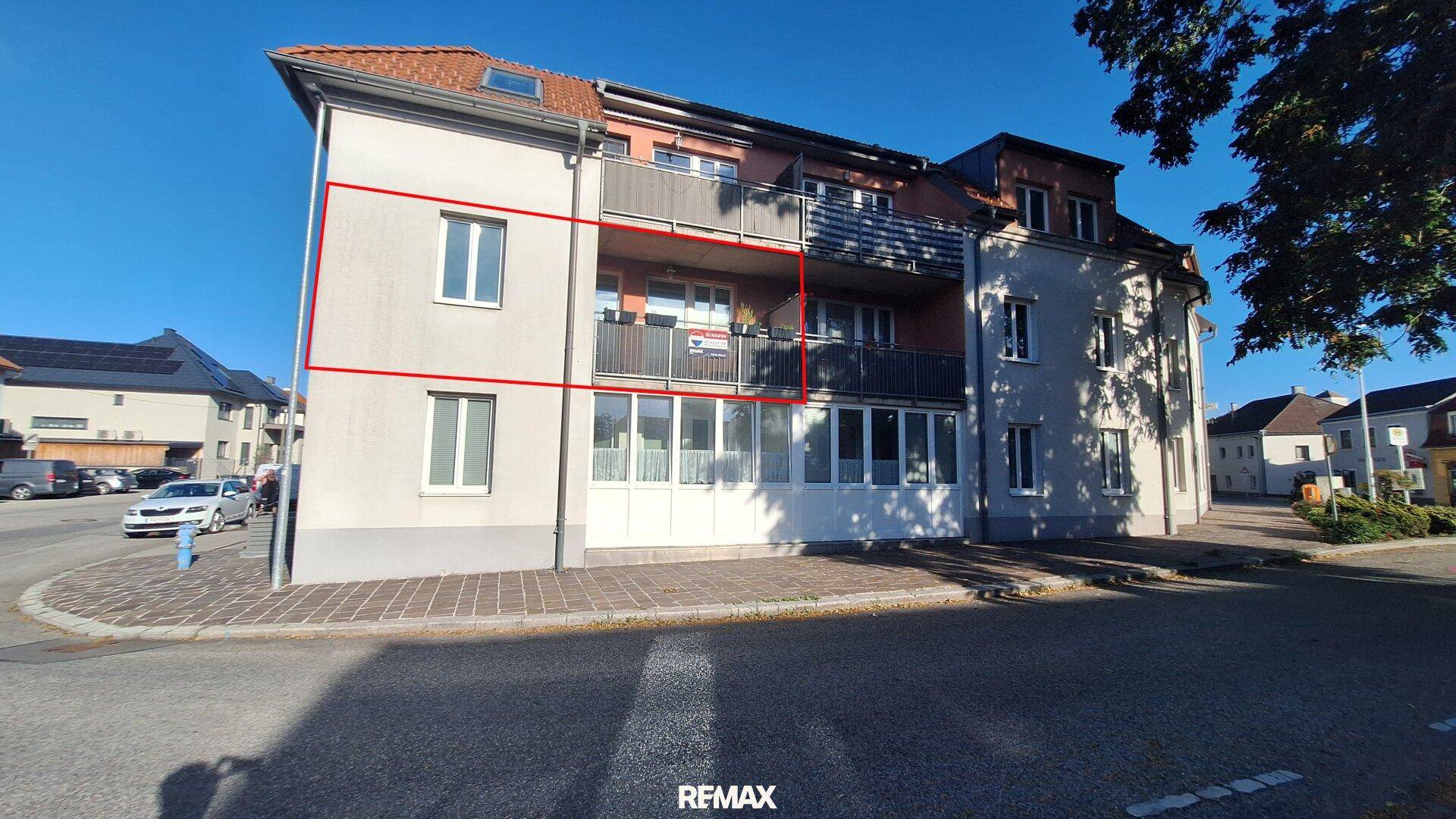 Mehrfamilienhaus mit Balkonen und großen Fenstern in einer städtischen Umgebung.