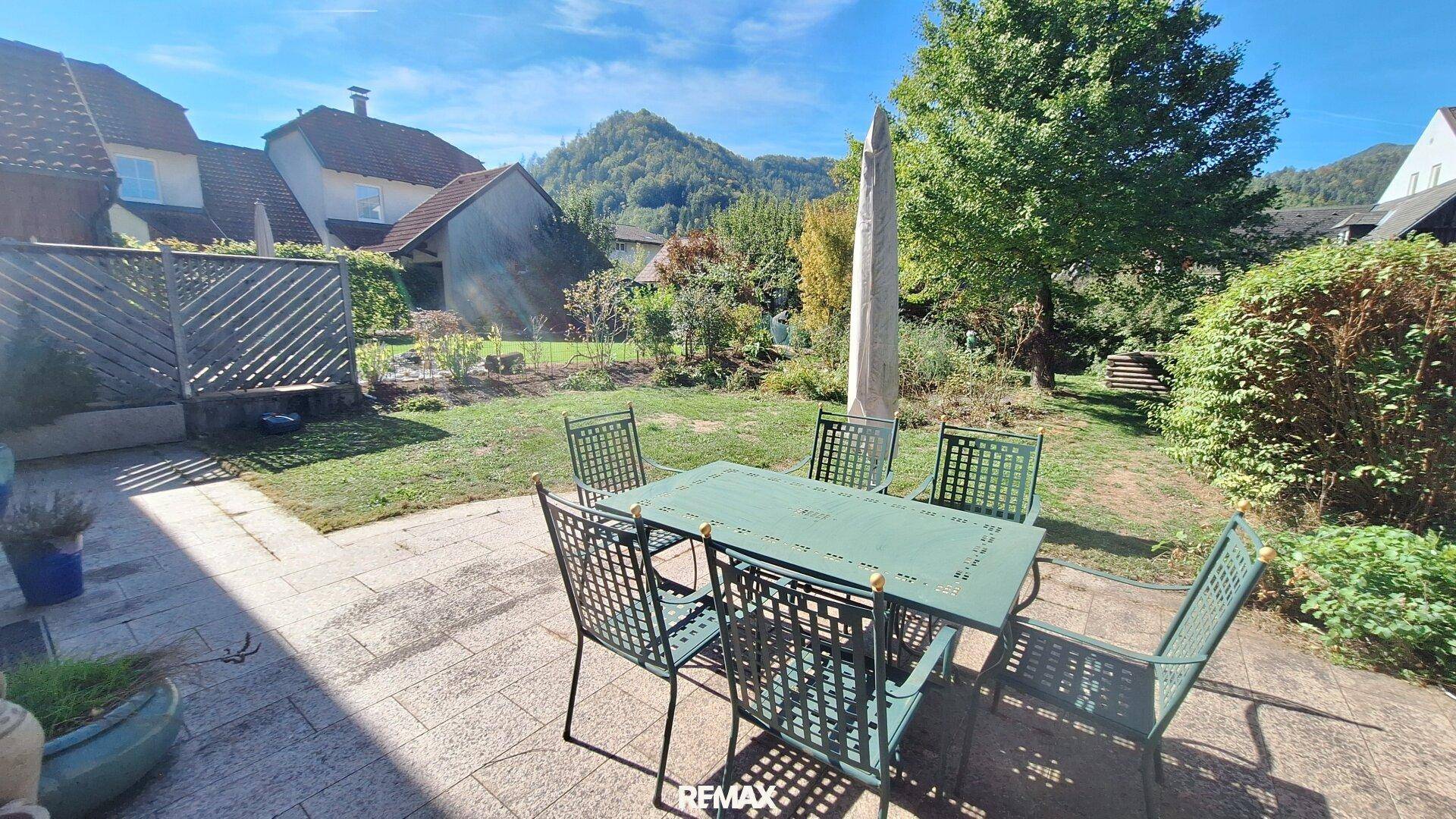 Sonnige Terrasse mit Gartenmöbeln und weitem Blick auf die grüne Landschaft.