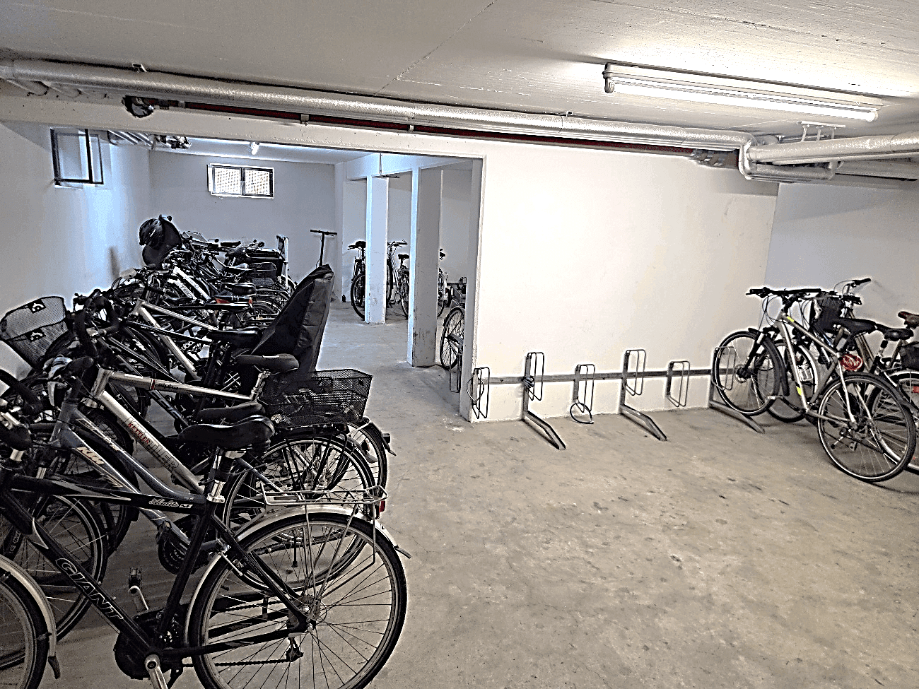 Fahrradraum im Untergeschoss mit zahlreichen Fahrrädern und Abstellmöglichkeiten.
