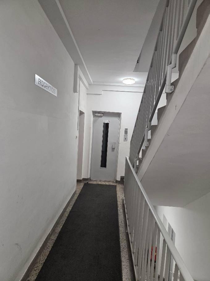 Heller Hausflur mit Aufzug und Treppenhaus, der Zugang zu den Wohnungen bietet.