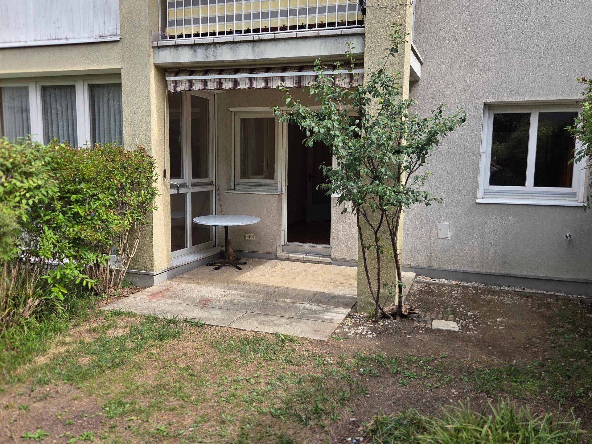 Gemütliche Terrasse im Erdgeschoss mit kleinem Tisch und direktem Zugang zum Garten.