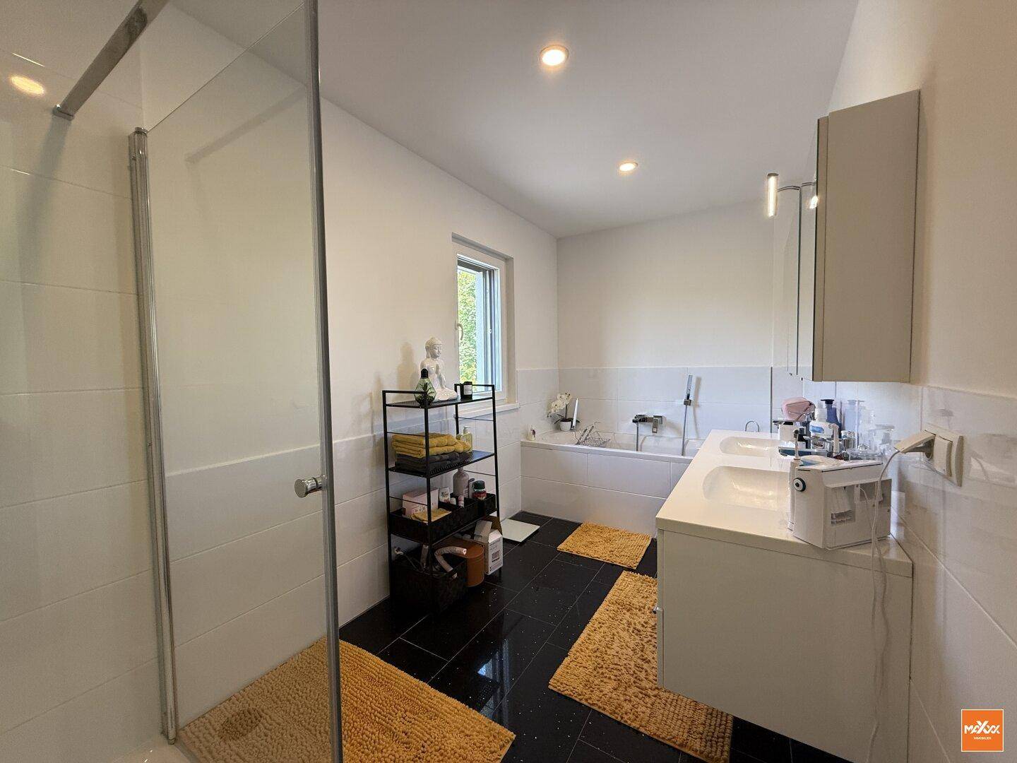 Modernes Badezimmer mit Doppelwaschbecken, Badewanne und großer begehbarer Dusche.