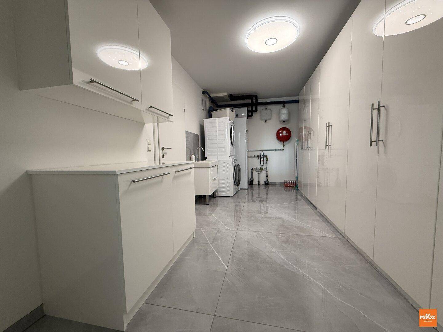 Praktischer Hauswirtschaftsraum mit Waschmaschine, Trockner und viel Stauraum.