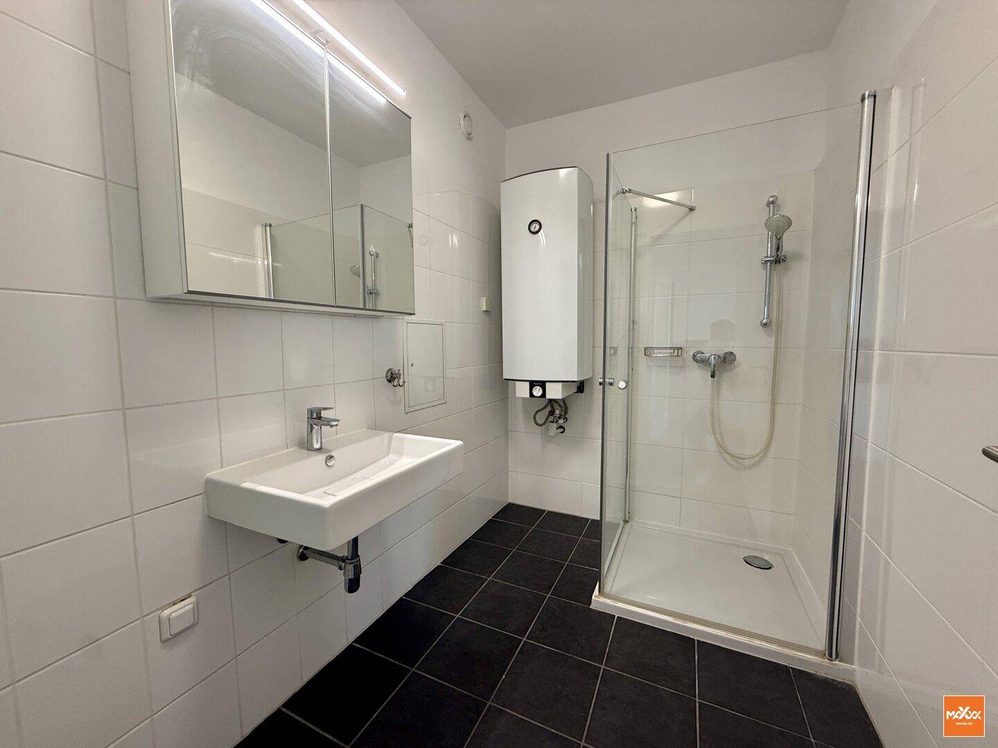 Modernes Badezimmer mit Duschkabine, Waschbecken und praktischem Spiegelschrank.