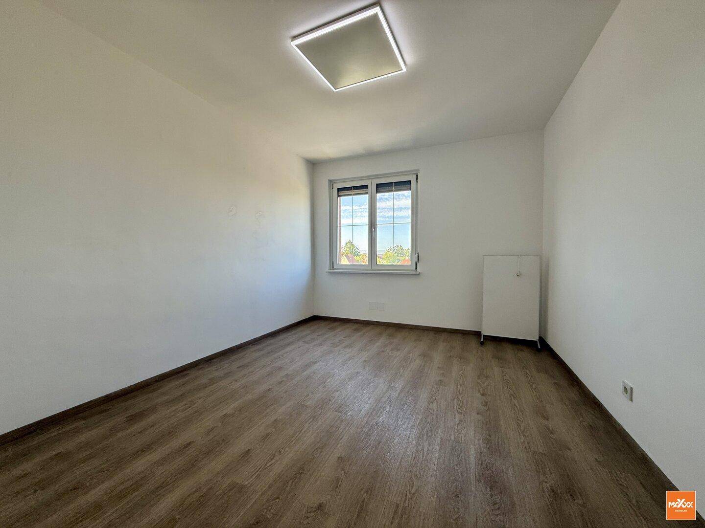 Freundliches Zimmer mit Laminatboden und Fenster, bietet vielseitige Nutzungsmöglichkeiten.