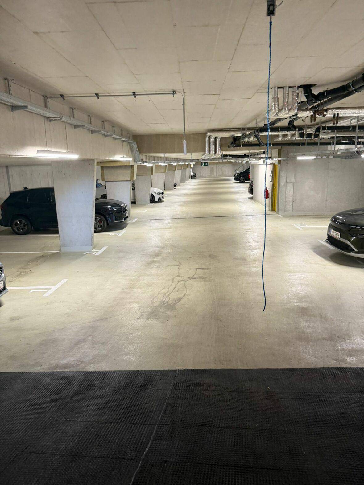 Geräumige Tiefgarage mit vielen markierten Stellplätzen und moderner Beleuchtung.