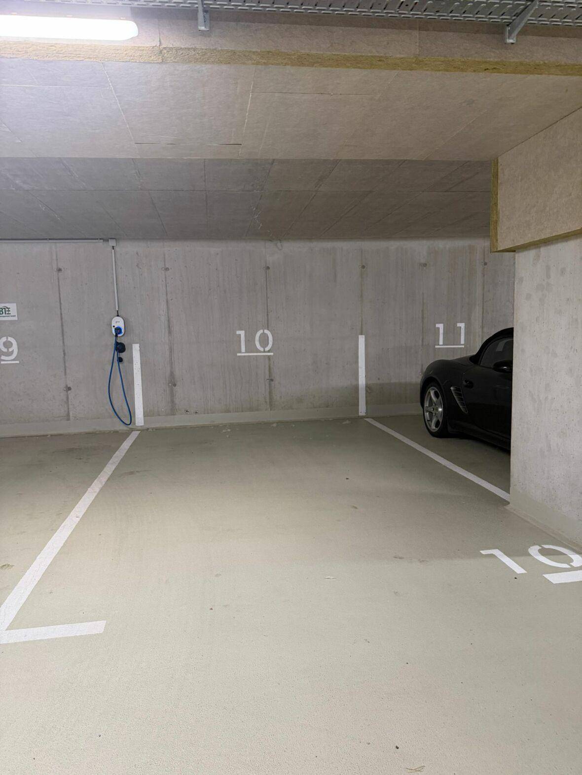 Stellplatz in einer Tiefgarage mit einer Ladestation für Elektrofahrzeuge.