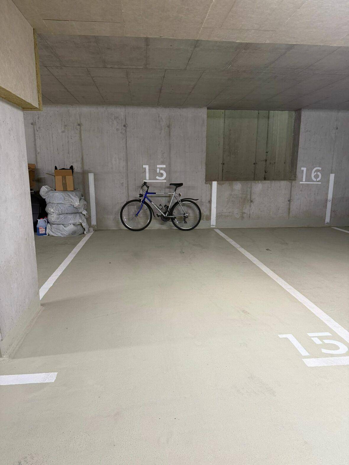 Geräumiger Stellplatz in einer Tiefgarage mit Betonwänden und einem abgestellten Fahrrad.