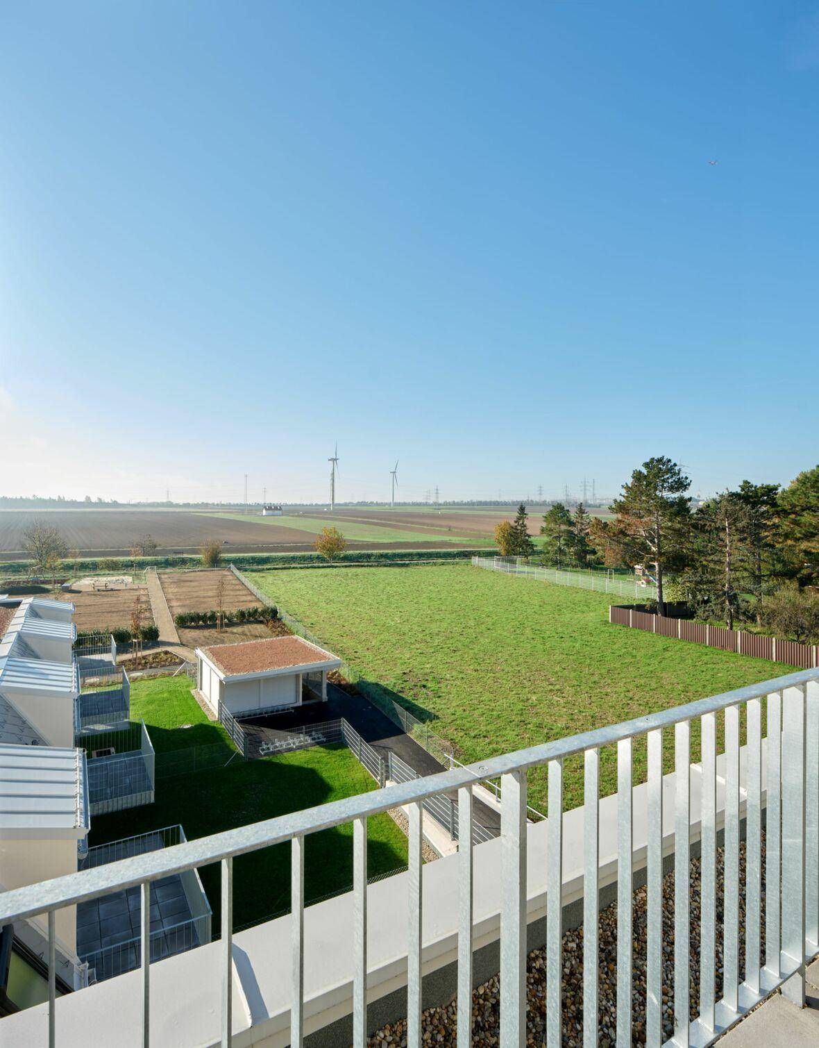 Weitläufiger Blick über grüne Felder und Windräder von der oberen Etage des Gebäudes.