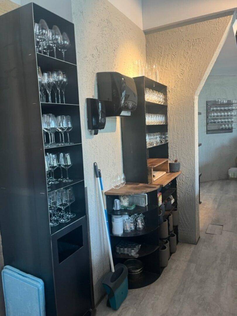 Lagerbereich mit Regalen voller Gläser und Utensilien, bereit für den Service in der Gastronomie.