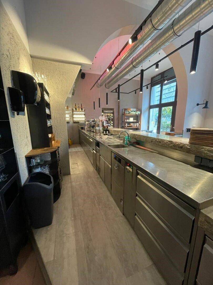 Professionelle Küche mit Edelstahloberflächen, Spülbecken und Geräten, bereit für den Gastronomiebetrieb.