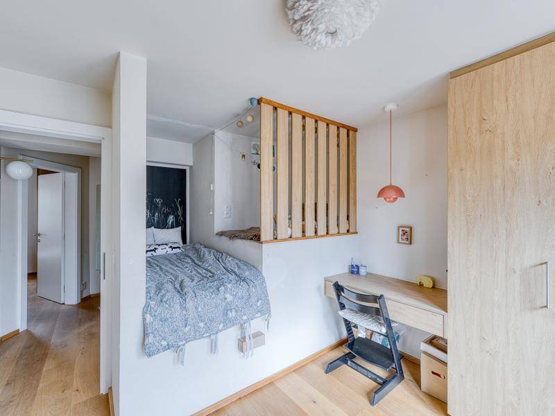 Kinderzimmer mit Hochbett, Schreibtisch und Holzboden, optimiert für kleine Räume.