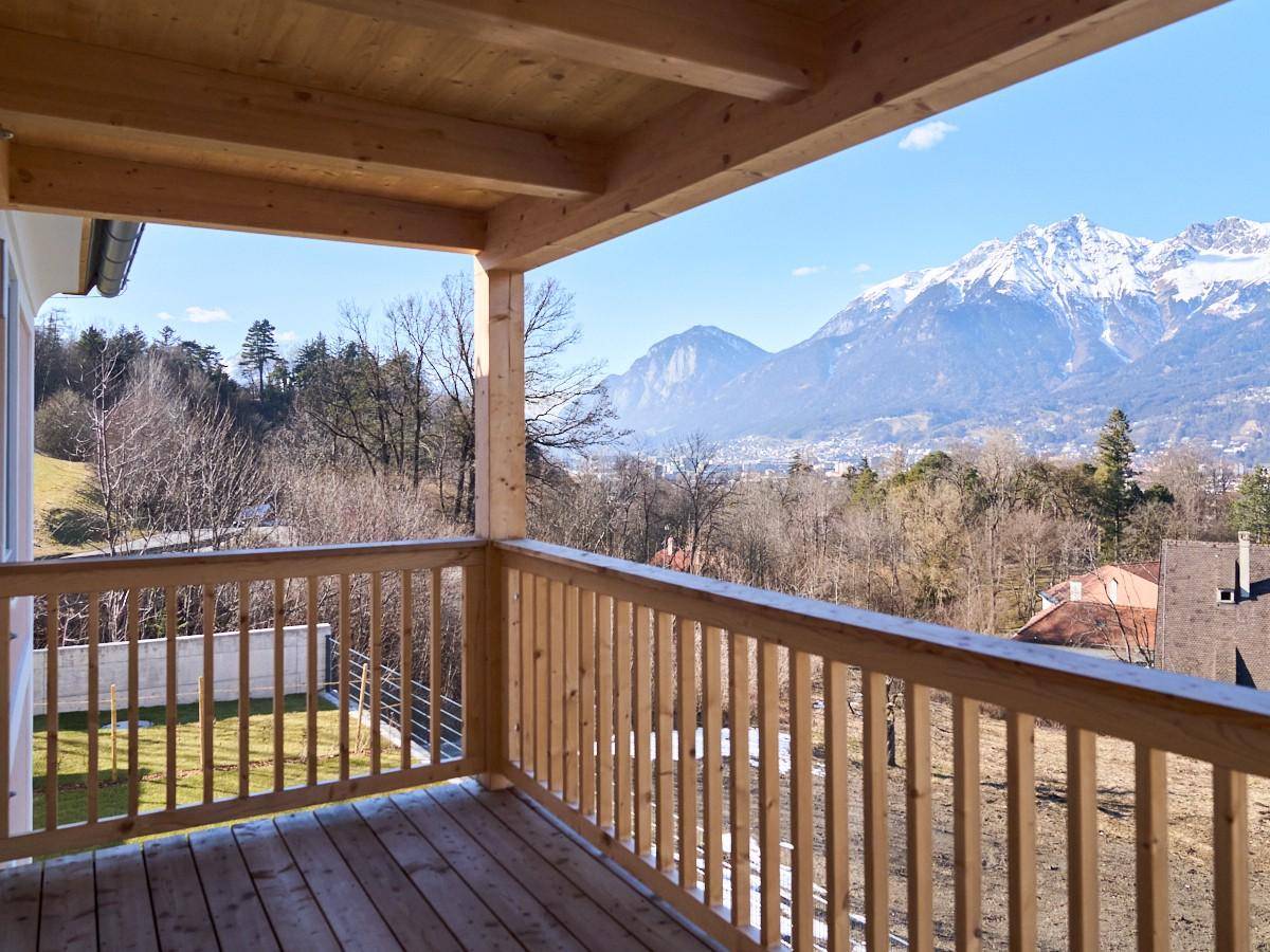 Geräumiger Holzbalkon mit atemberaubendem Blick auf die umliegende Berglandschaft.