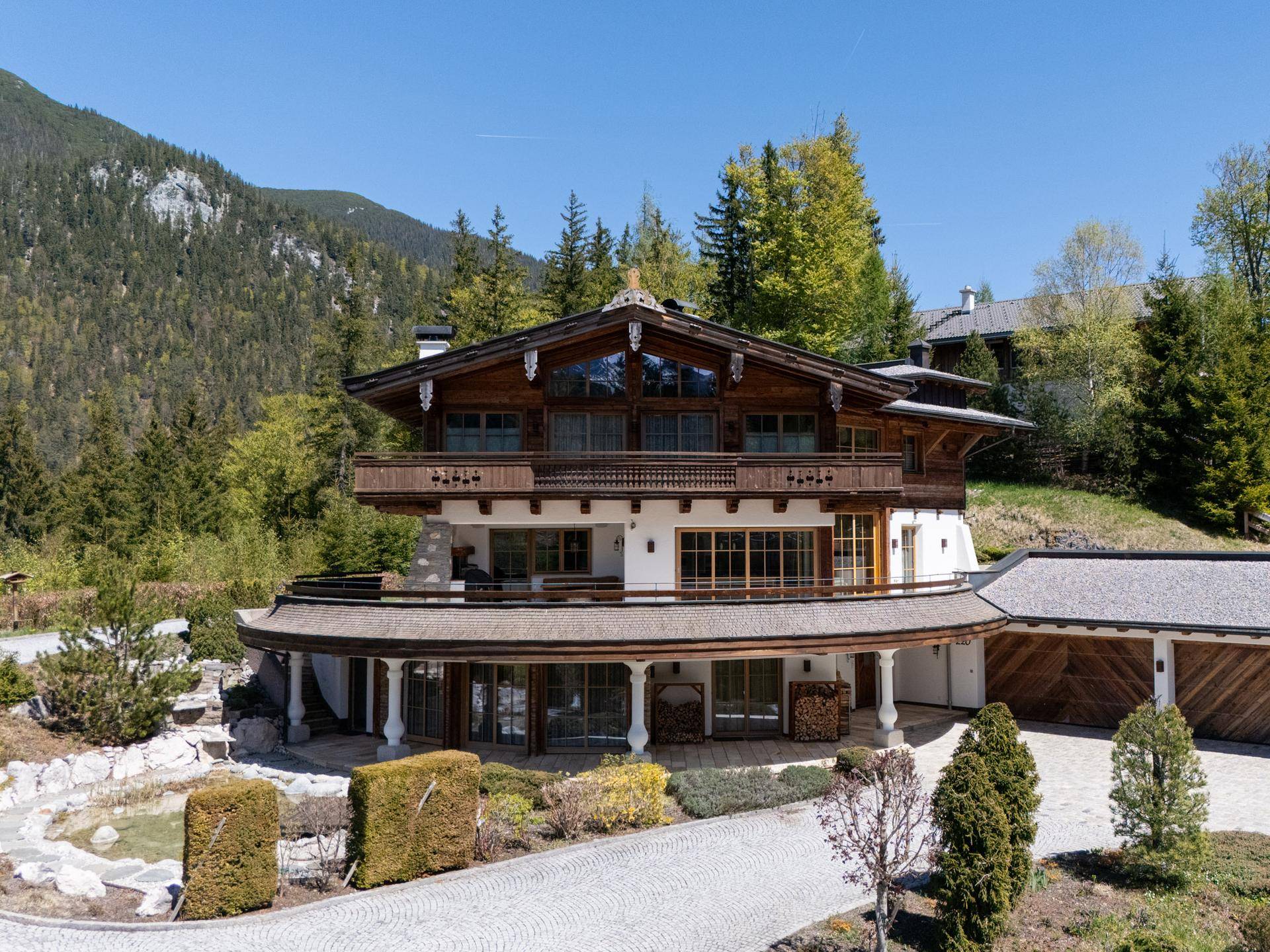 Luxuriöses Chalet mit weitläufiger Auffahrt und integrierter Garage in alpiner Umgebung.