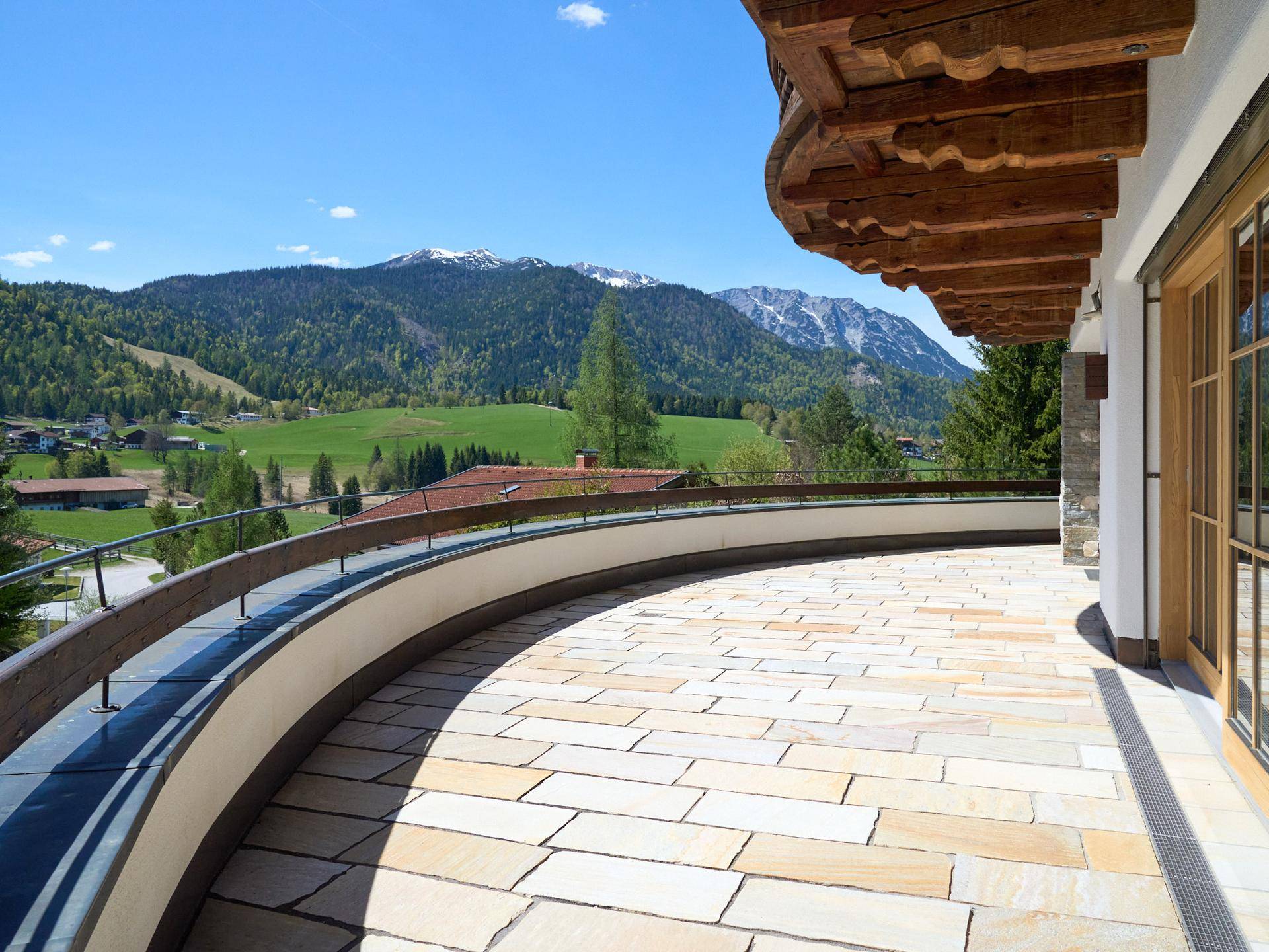 Weitläufige Terrasse mit Steinplatten und Panoramablick auf die umliegende Bergwelt.