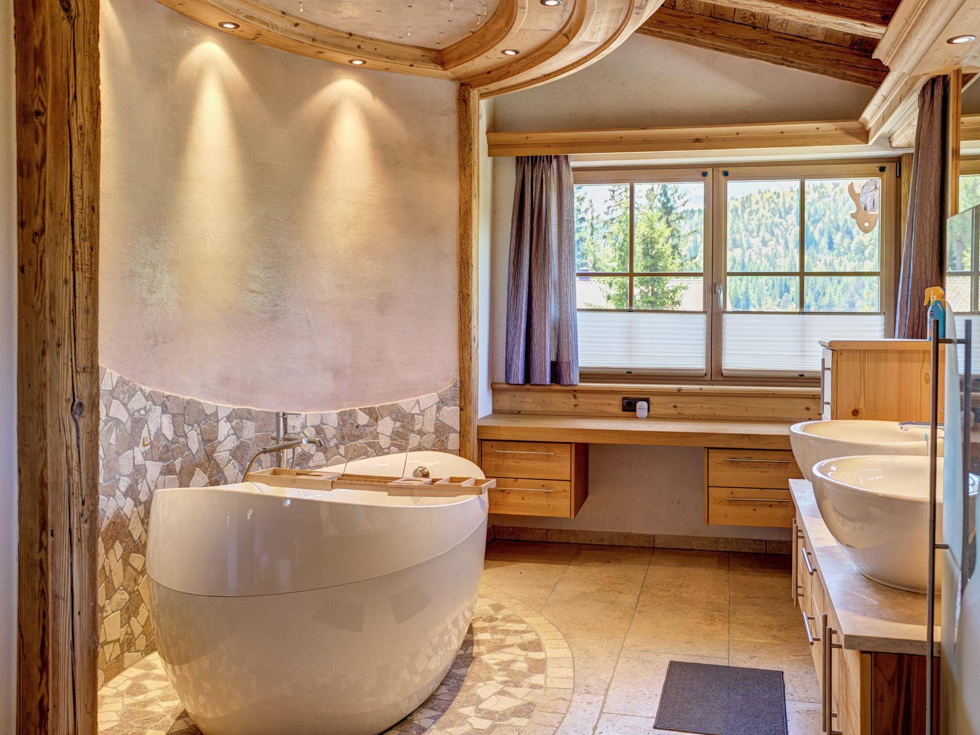 Modernes Badezimmer mit freistehender Badewanne, Doppelwaschbecken und Fensterblick.