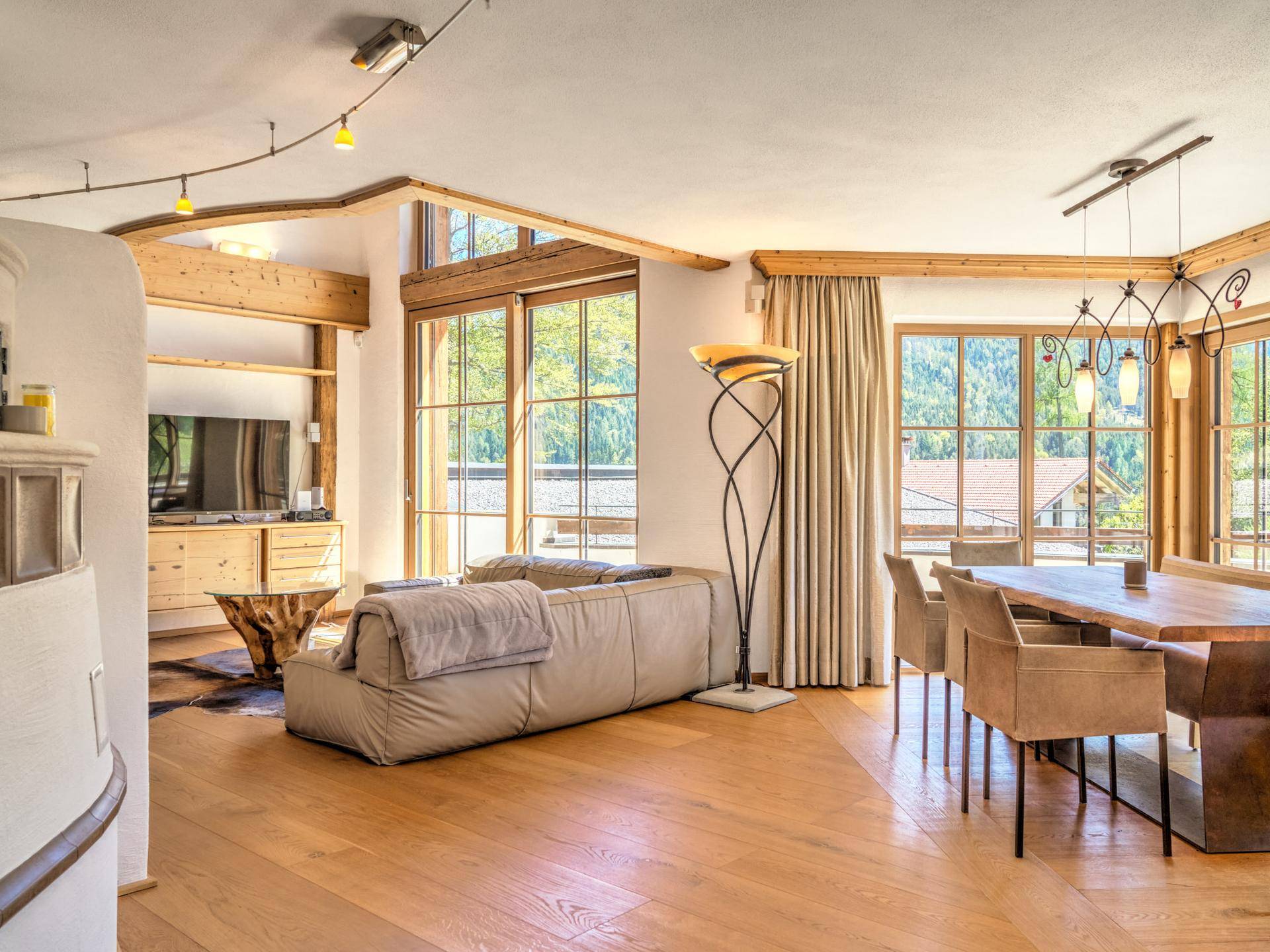 Geräumiger Wohnbereich mit gemütlicher Couch, Holzbalken und Zugang zur Terrasse.