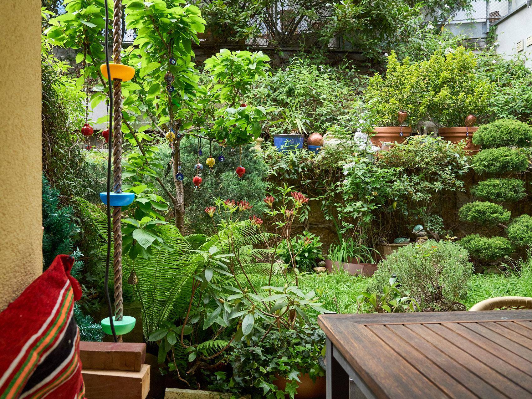Üppiger, dicht bewachsener Gartenbereich mit vielfältigen Pflanzen und dekorativen Elementen.
