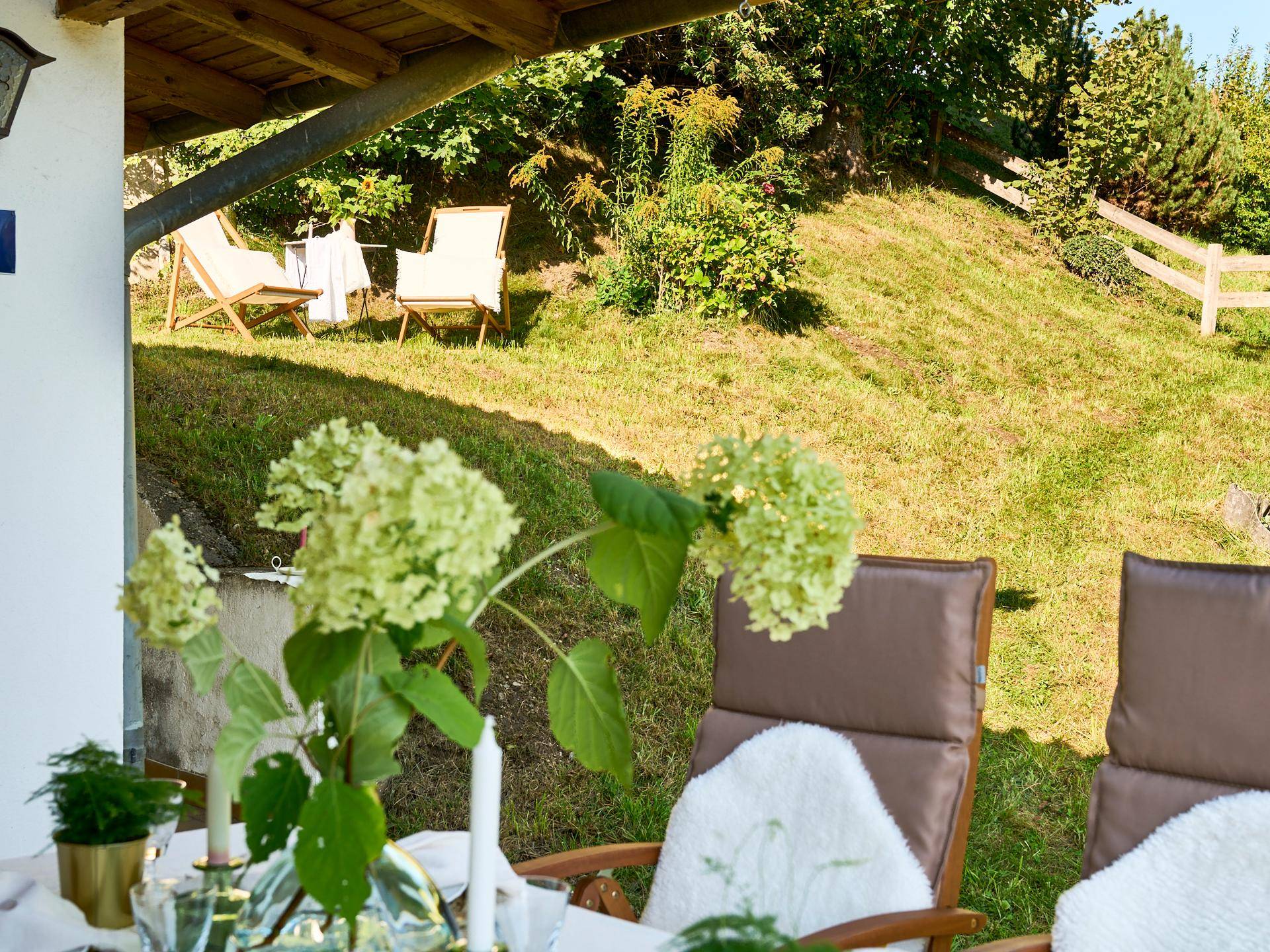 Gedeckter Tisch auf der Terrasse mit Blick auf den gepflegten Garten und die sonnige Umgebung.