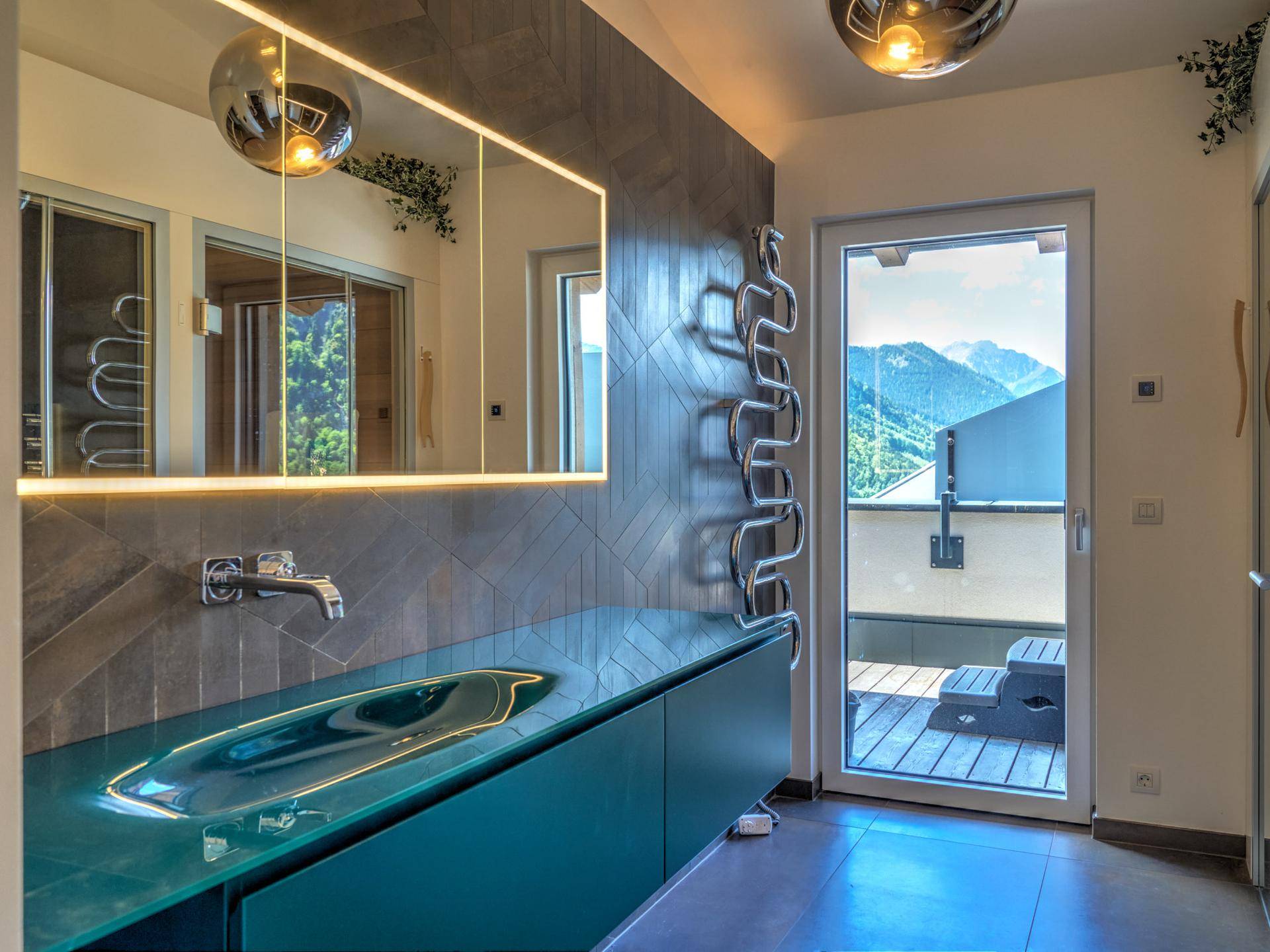 Modernes Badezimmer mit einzigartigem Waschbecken, beheiztem Handtuchhalter und Bergblick.