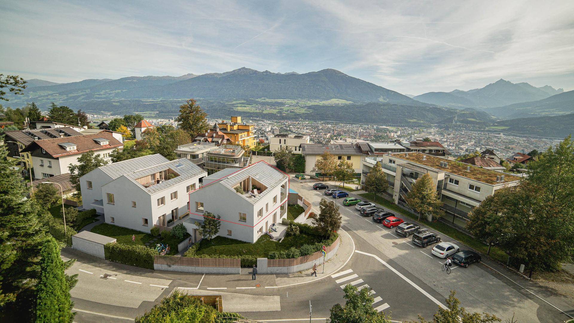 Luftaufnahme einer Wohnsiedlung mit modernen Gebäuden und weitem Blick über die Stadt und die Berge.
