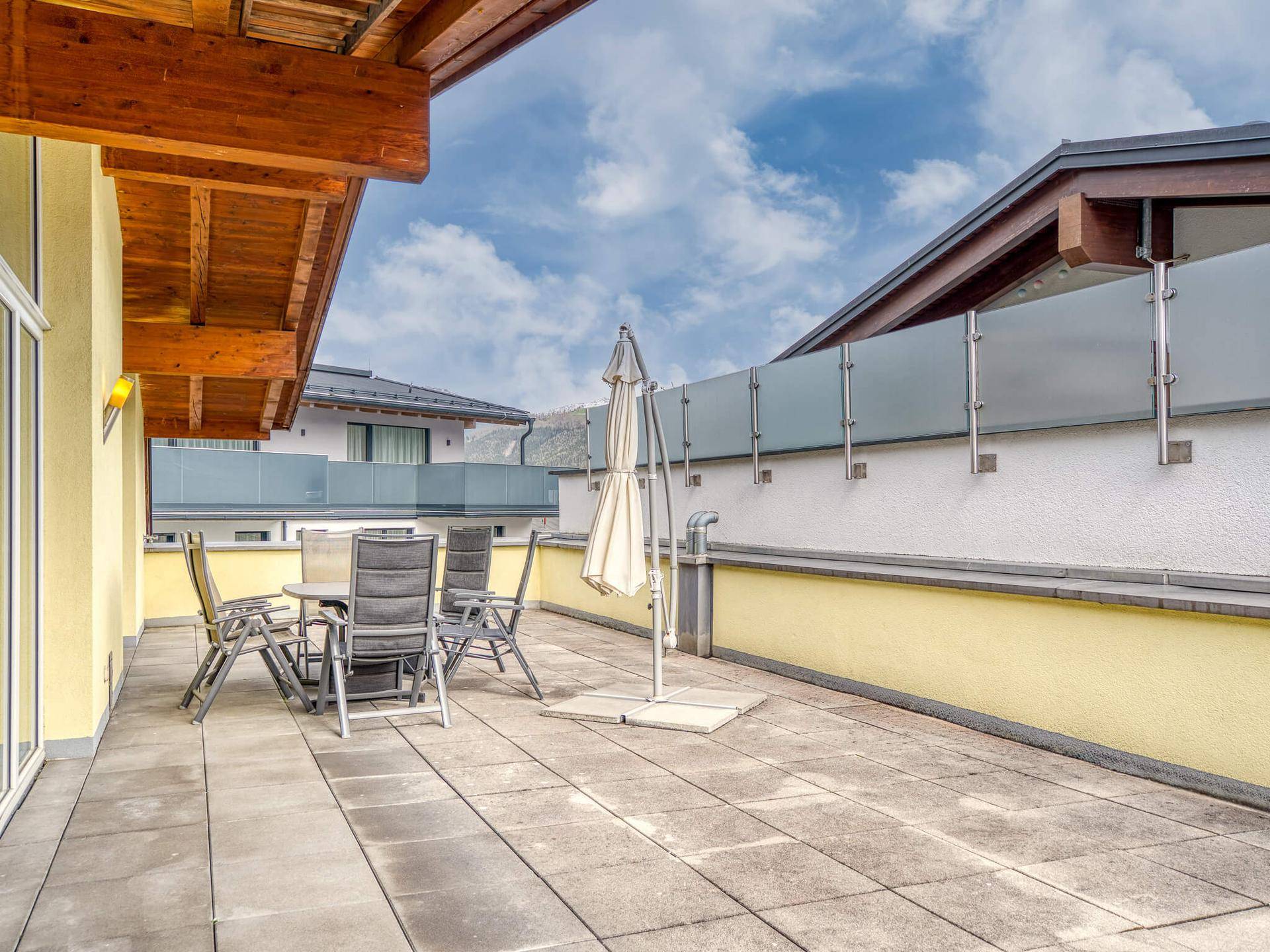 Geräumige Dachterrasse mit Sitzgelegenheiten und Blick auf die umliegenden Gebäude.