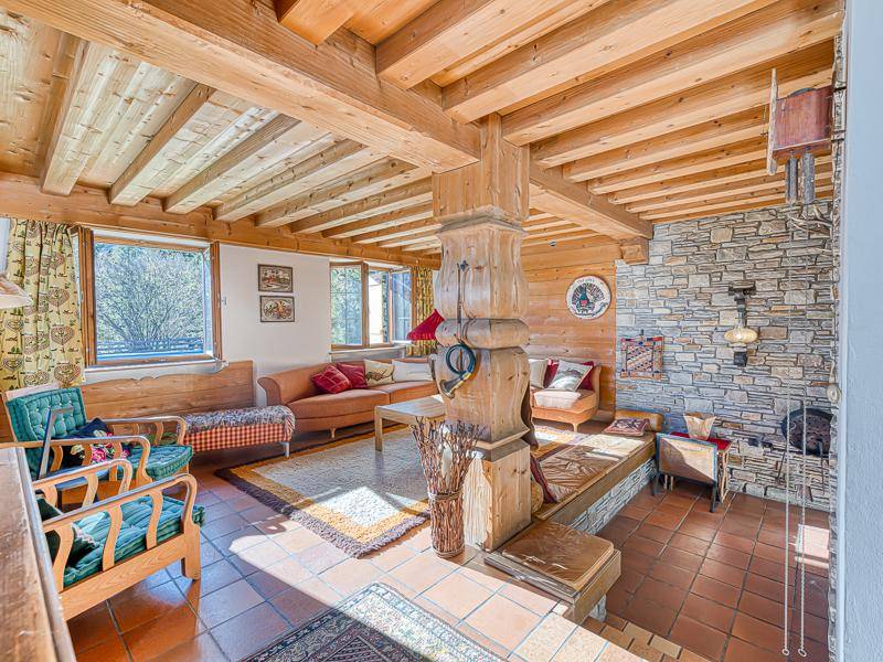 Rustikales Wohnzimmer mit Holzbalkendecke, Steinwand und traditionellen Sitzgelegenheiten.