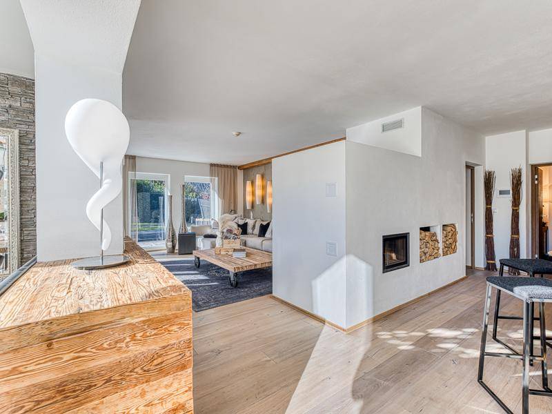 Offener Wohnbereich mit Holzboden, modernem Kamin und stilvoller Dekoration.