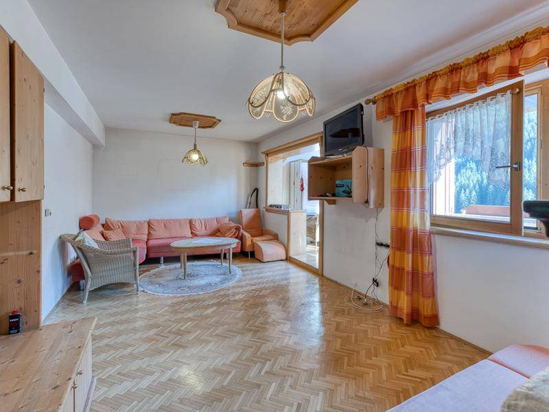Helles Wohnzimmer mit bequemer Sitzecke, Fischgrätparkett und Blick ins Grüne.