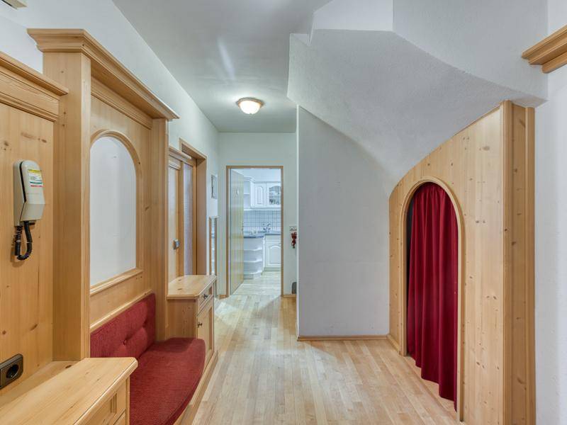 Heller Flur mit traditioneller Holzvertäfelung, integrierter Sitzbank und Holzboden.