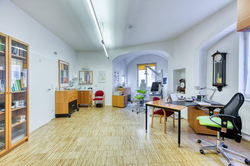 Heller Büroraum mit medizinischer Ausstattung, Schreibtischen und Bücherregalen.