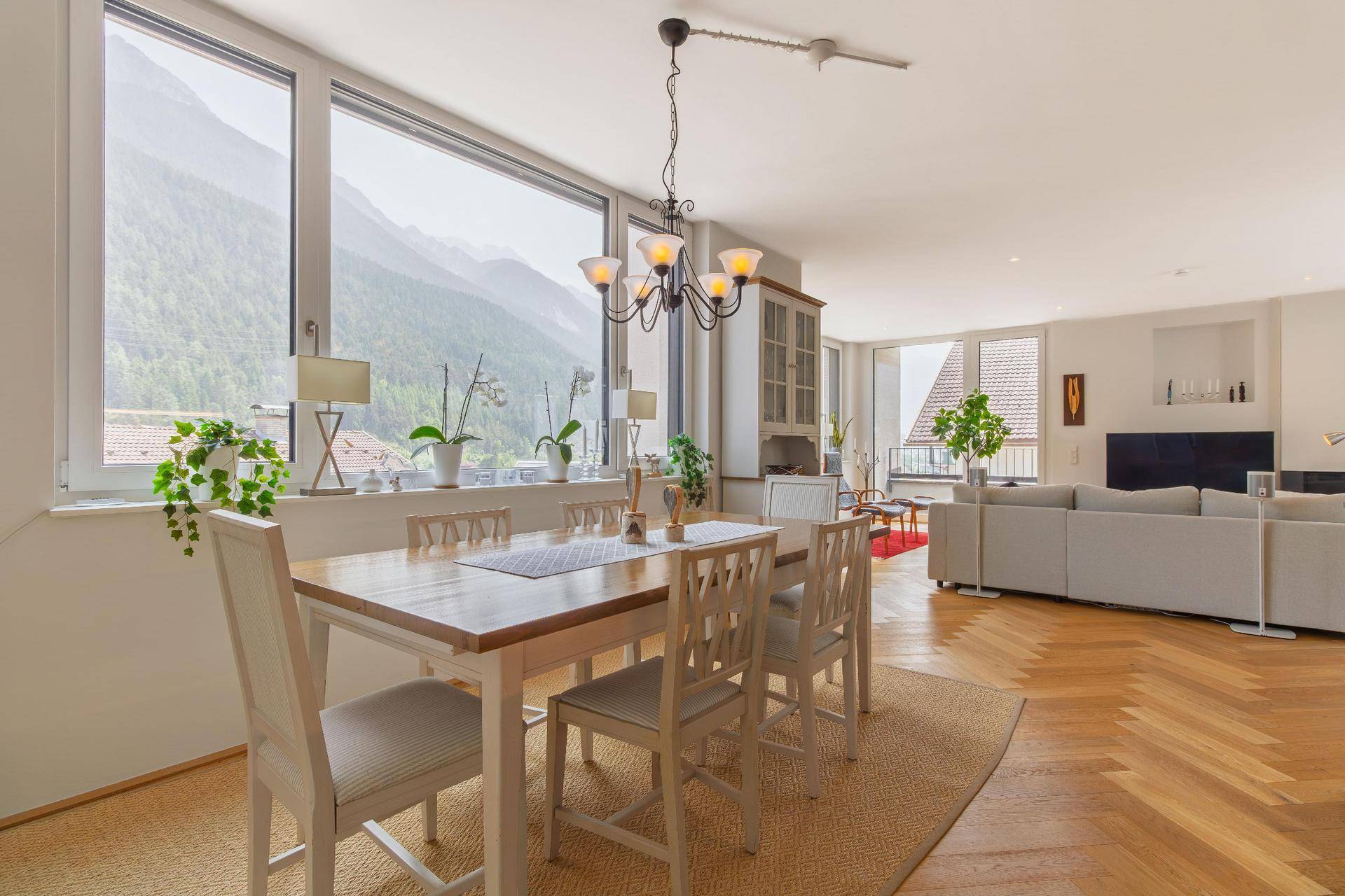 Essbereich mit großem Fenster, das einen weiten Blick auf die umliegende Berglandschaft bietet.