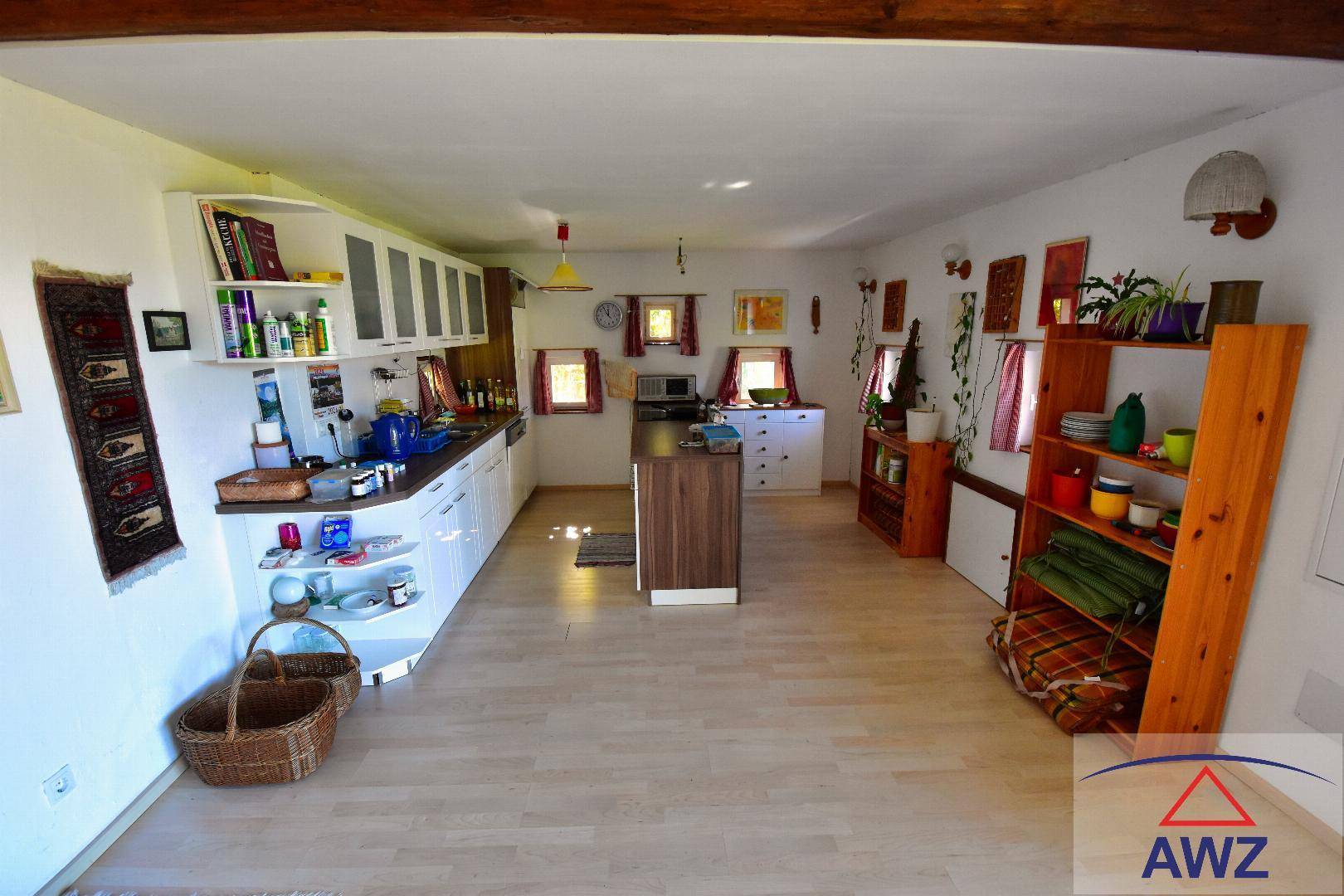 Funktionale Küche mit weißen Schränken, Holztheke und kleiner Kücheninsel.