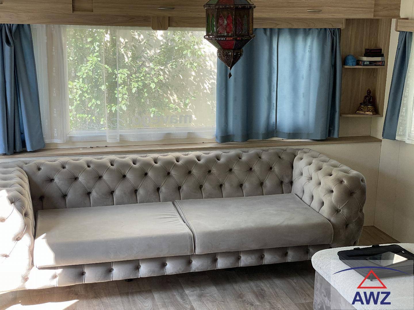 Helles Wohnzimmer mit einem großen, bequemen Sofa und Blick ins Grüne.