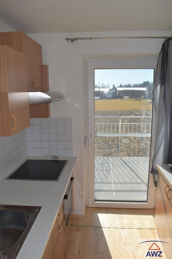 Küchenbereich mit Zugang zum Balkon und Blick auf die umliegende Landschaft.
