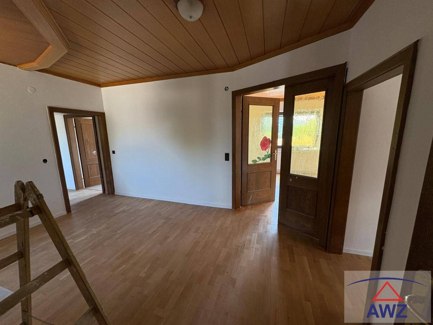 Geräumiger Flur mit Holzbalkendecke, Parkettboden und traditionellen Holztüren.